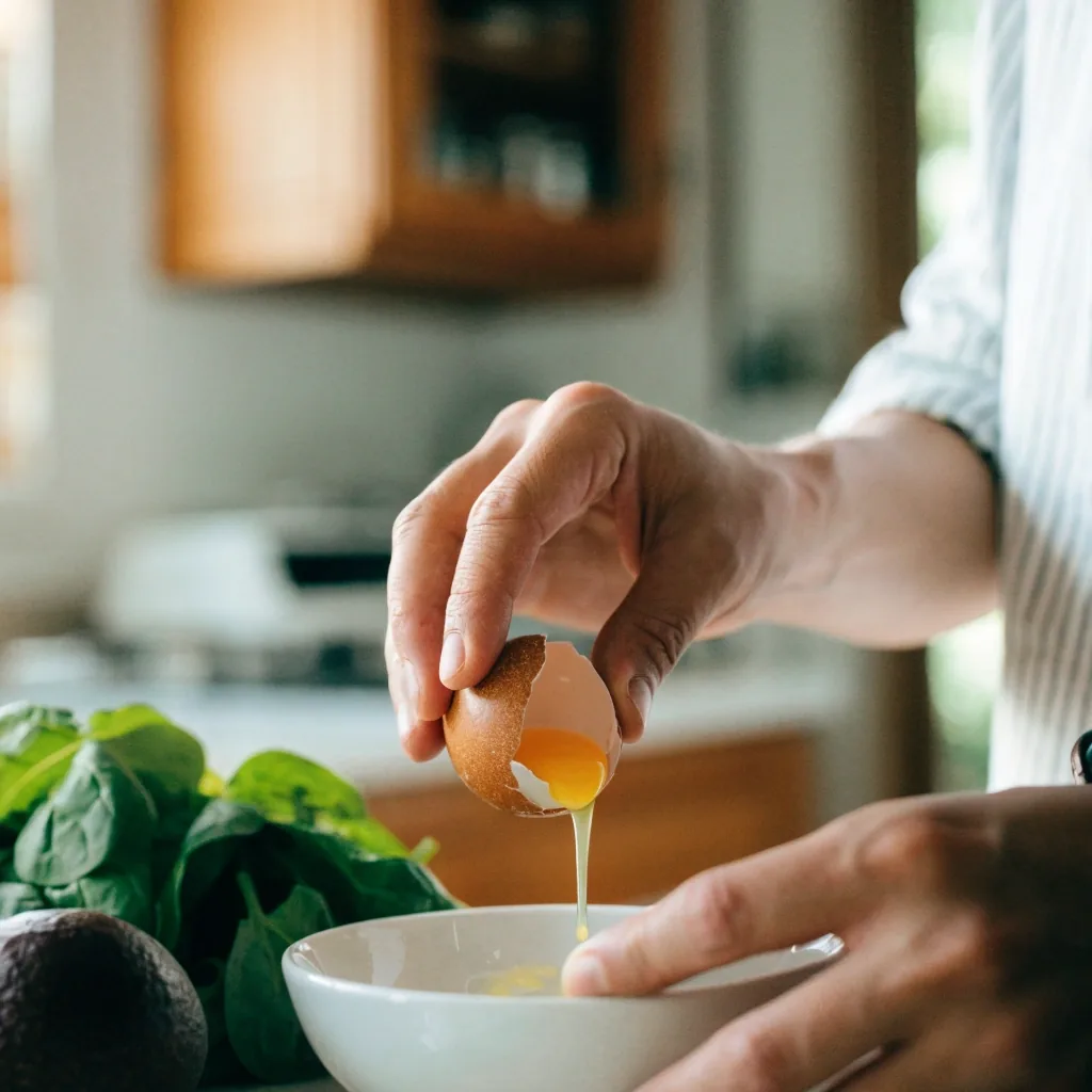 A broken egg yolk in a shallow white ceramic bowl